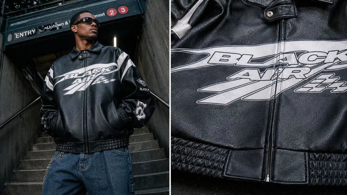 Black racing-graphic streetwear jacket paired with blue jeans at a subway entrance