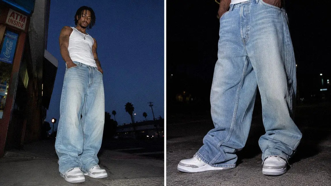 Wide light-wash streetwear jeans worn with a white tank top on a dusk city street