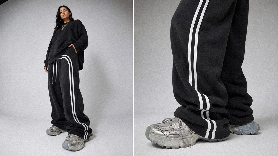 Side-striped streetwear sweatpants paired with chunky silver sneakers in close-up