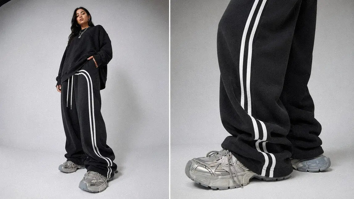 Side-striped streetwear sweatpants paired with chunky silver sneakers in close-up