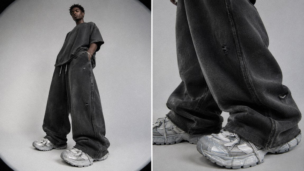 Distressed charcoal streetwear sweatpants showing faded, worn surface detail