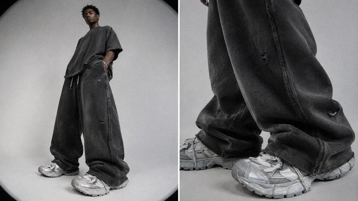 Distressed charcoal streetwear sweatpants showing faded, worn surface detail