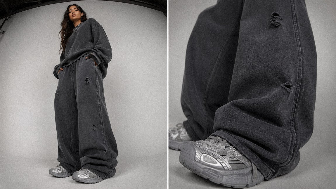 Distressed dark grey streetwear sweatpants styled with an oversized crewneck sweater