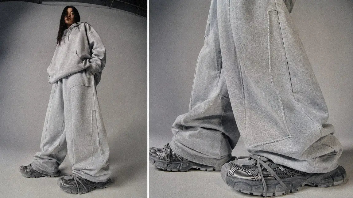 Full side profile of oversized light grey streetwear sweatpants in a wide-leg cut