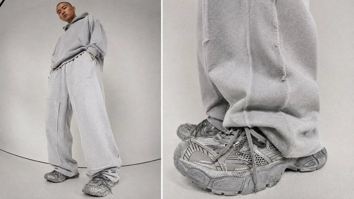 Oversized grey streetwear sweatpants and hoodie set on a plain studio background