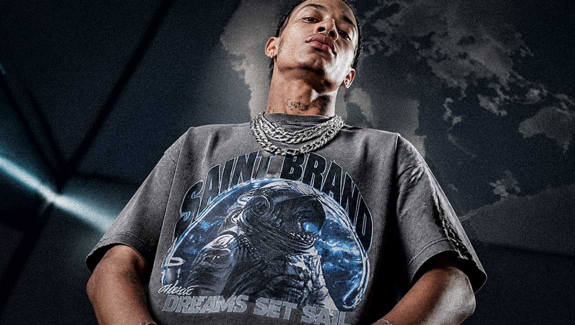 A low-angle fashion portrait highlights a grey Streetwear t-shirt decorated with an astronaut graphic.