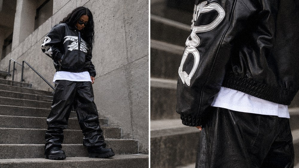 Woman in a black leather varsity jacket and wide trousers styled for women's dark streetwear