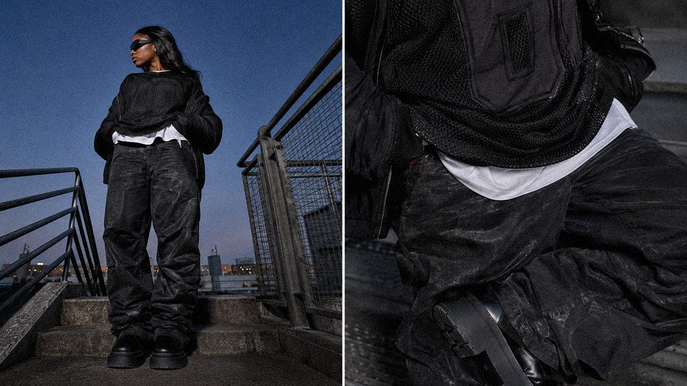 Layered graphic sweater and white tee hem building a dark streetwear wardrobe combination
