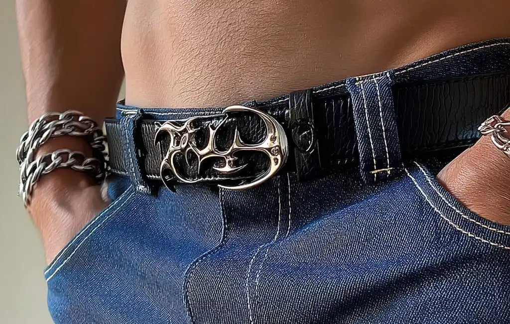 Black streetwear belt with silver studs and a classic metal buckle paired with dark jeans.